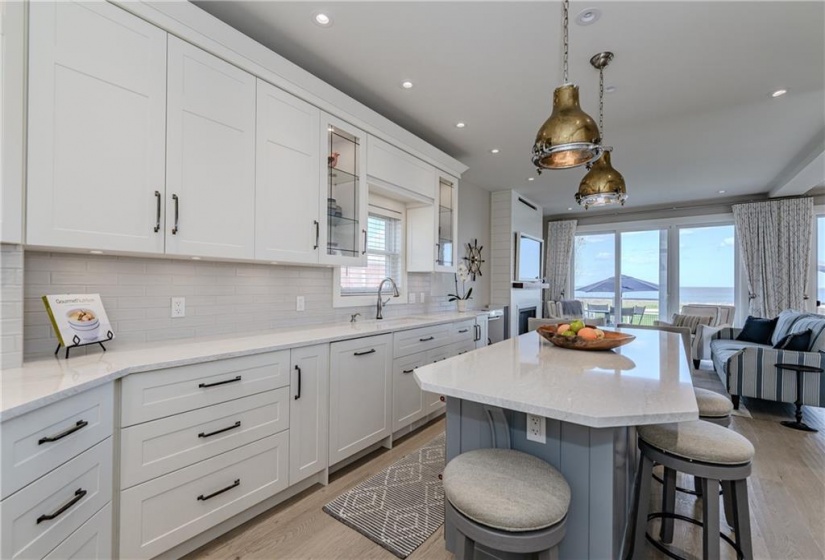 Antique brass pendant lighting offers an intriguing contrast to the long stretches of Corian quartz countertops, not to mention a conversation starter.