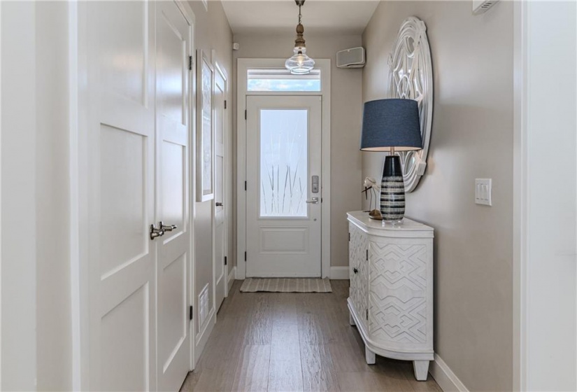 The entry brings a sense of peace right from the moment you set foot inside. Transom window and glass front door offer beautiful sunlight cascading over the wide plank hickory hardwood flooring leading straight through the entire main level.