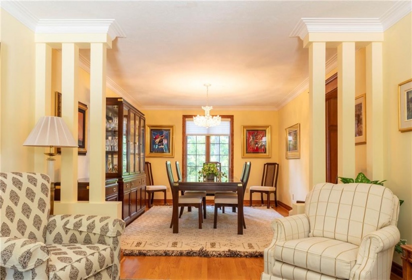 The formal living room stretches into the dining area. Pilars define each area while hardwood floors carry a seamless look throughout both rooms. Large Feldman Aluminium Clad Casement Windows bring light from either end, bringing sunlight and warmth to this fabulous entertaining space.