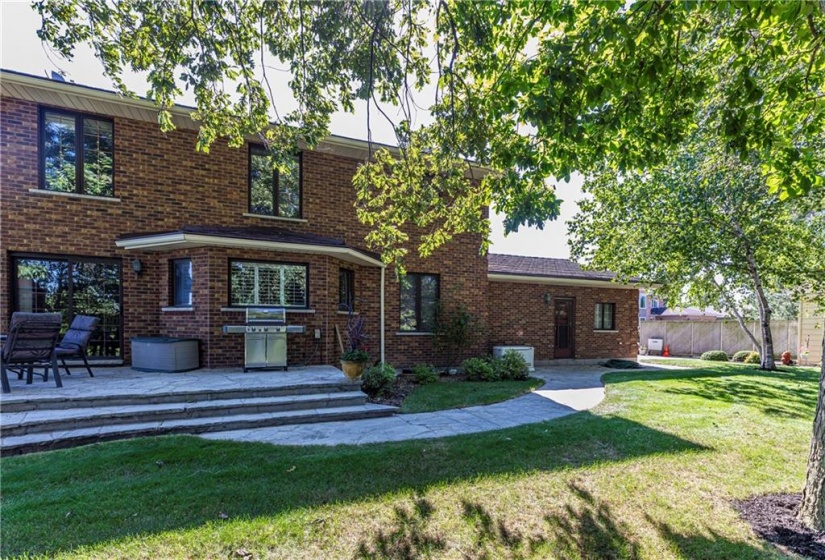 The large flagstone patio is accessible from the kitchen to enjoy quiet evening meals outside. A walkway extends outward towards the garage and driveway taking you for a post-meal walk through the neighbouring streets.