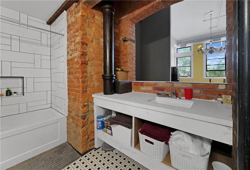 exposed brick and beam washroom with soaker tub