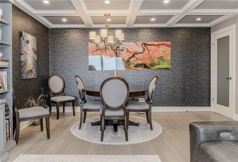 Set underneath a beautiful coffered ceiling with pot lighting and overhead fixture, you have room to expand the dining room for as intimate or as large as you need.