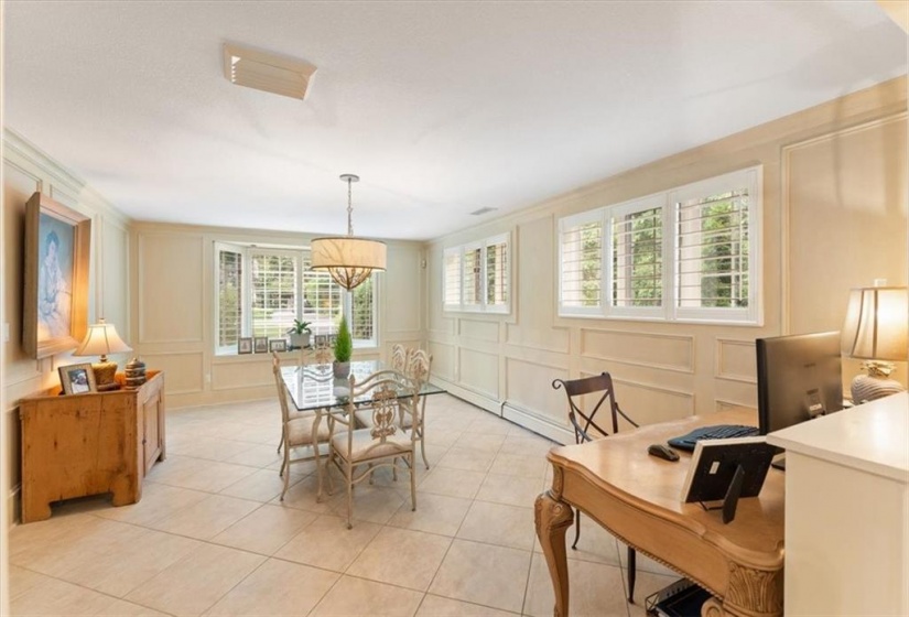 Family room or casual dining room. Plantation shutters (2023) Heated tile floor. Dark Oak wood panelling has been painted. All baseboard heating throughout is connected to the gas boiler. Crown moulding, bay window. Adjoins kitchen.