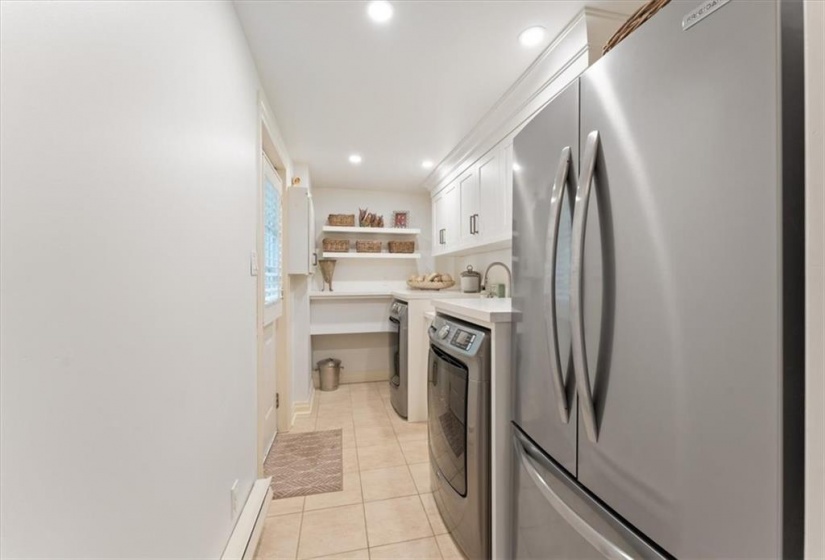 Laundry room remodelled 2023 by Gravelle. Frigidare stainless fridge, Maytag washer and dryer. Quartz countertop. Beautiful Shaker cabinetry. Deep stainless sink with Kohler handspray. Door to side garden