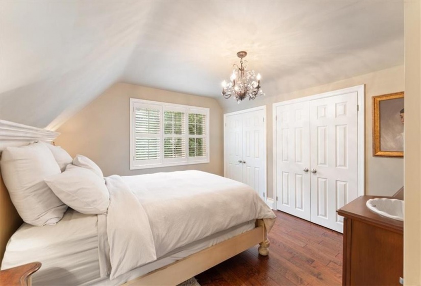 SE Bedroom. 2 double closets. Vanity with sink. Handscraped dark hardwood flooring. Unique chandelier. California shutters.