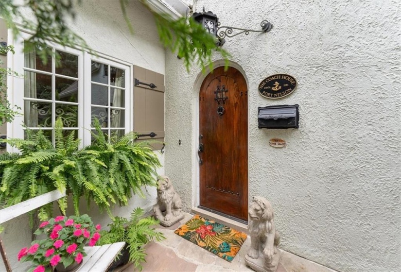 Custom ash front door with speak easy, bespoke imported hand hammered hardware on door and shutters.