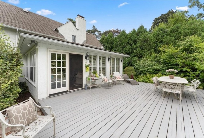 Sunroom to deck. Large cedar hedges on both sides.