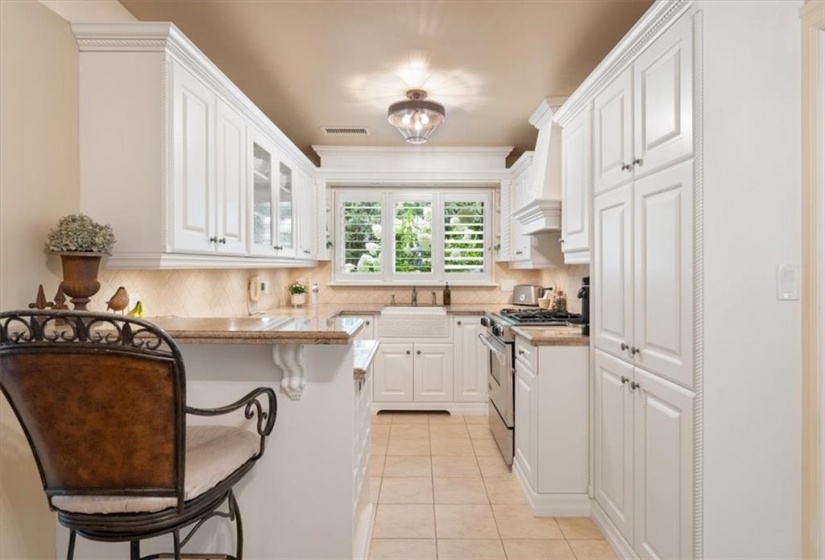 California shutters, granite countertops, tumbled marble backsplash, Kohler apron sink. Jenn Aire stainless dual fuel. Maytag dishwasher. Updated ceiling fixtures. Plantation shutters in 2023.