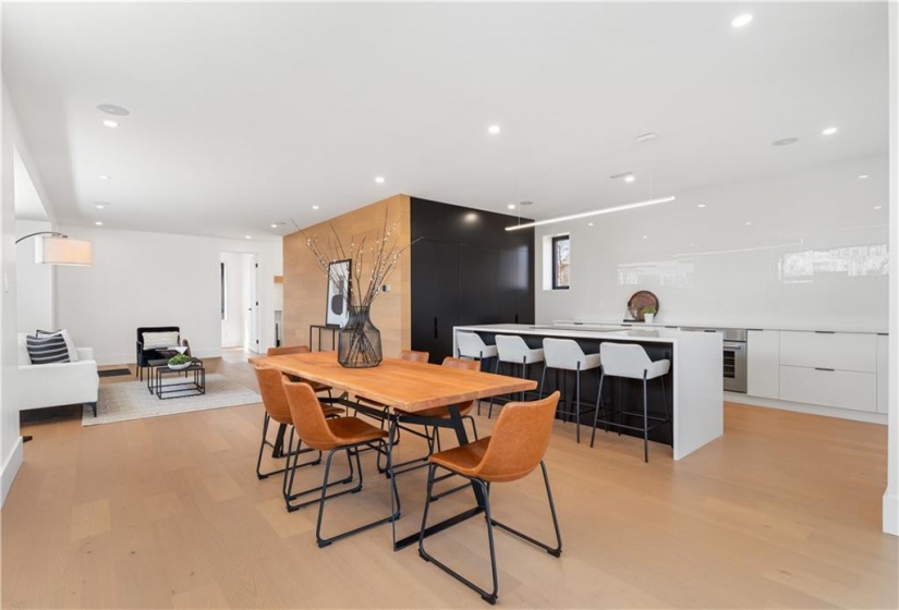 Open concept kitchen, dining, living. White oak flooring and feature wall. Speakers, pot lighting.