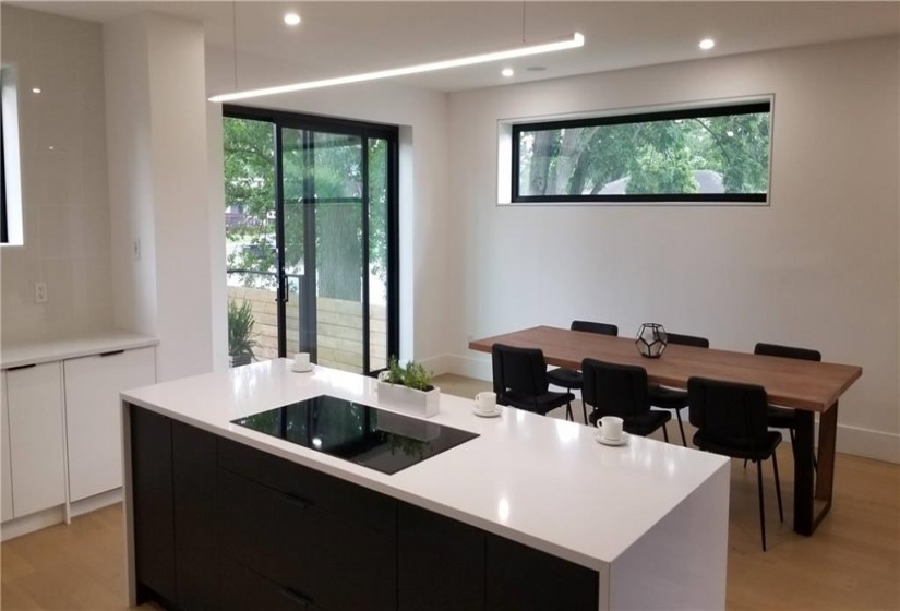 View of eating area and door to side garden. Privacy windows. White oak flooring