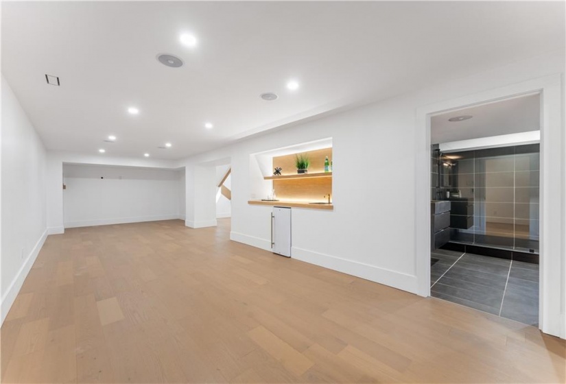 Lower level Family Room. Wet bar, bar fridge, ambient lighting on oak shelving. Spacious 3 piece bathroom.