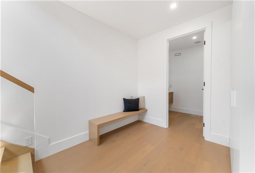 Mudroom. Built in bench. 2 huge double closets on right wall. Washroom. Glass stairway to upper level.