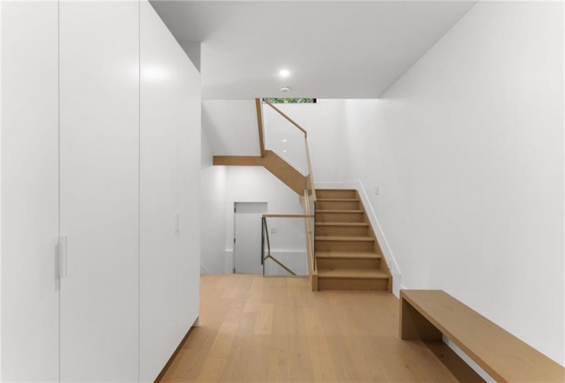 Mudroom. Floating bench. View from 2 pc to upstairs & side door. 2 Large double closets with lower pull-outs.