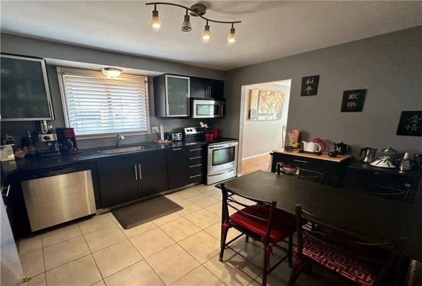 Main floor eat-in Kitchen w/black granite counter tops, SS appliances, and pullout pantry cupboard