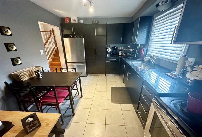 Main floor eat-in Kitchen w/black granite counter tops, SS appliances, and pullout pantry cupboard